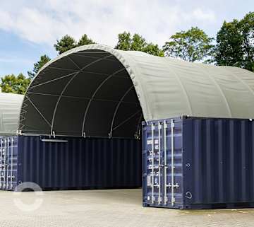 Containerüberdachung zwischen zwei blauen Seecontainern mit grauer PVC-Dachplane als wettergeschützte Lager- und Arbeitsfläche