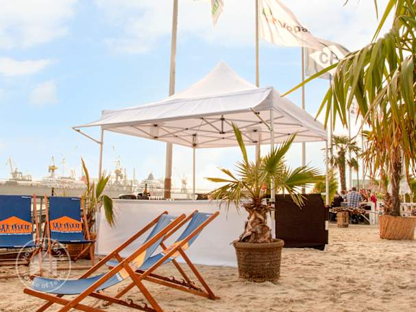 White 3x3 pop up gazebo set up on a beach with deck chairs and palm trees