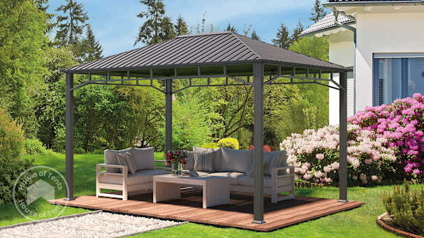Grey metal garden gazebo with curtains and steel roof, set up with outdoor lounge furniture on a wooden deck.