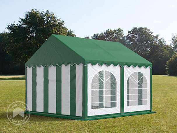 Green and white party tent with arched window panels on a grassy field