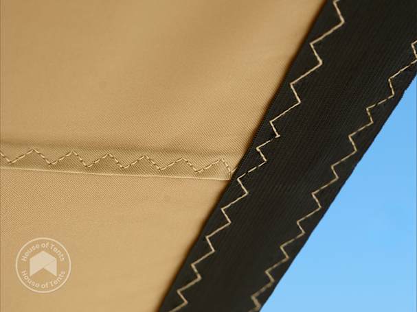 Close-up of stretch tent canopy fabric with reinforced zigzag stitching and coated material detail