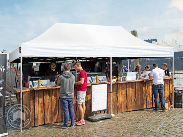 3x6 pop-up gazebo set up as an outdoor bar at a festival or market.