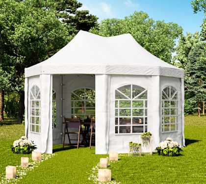 White pagoda-style gazebo with a pointed roof and arched window side panels in a garden.