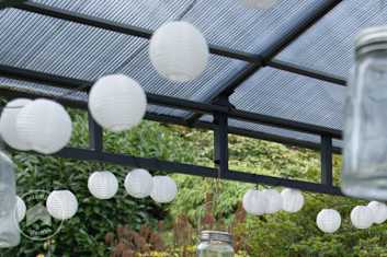 Accrochage de lanternes sur une tonnelle de jardin