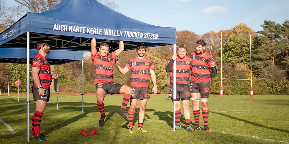 Ein mobiler Faltpavillon als Wetterschutz beim Rugby