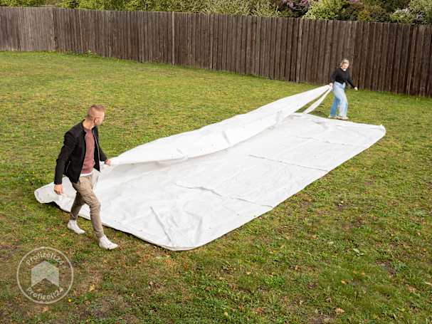 Die Partyzelt-Dachplane über die Breite zusammenlegen