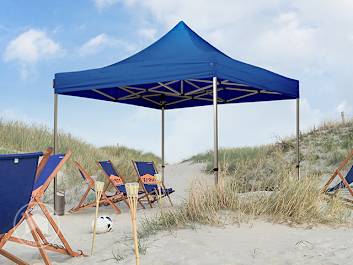 Ein blauer Faltpavillon am Strand