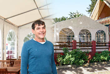 Restaurantbesitzer vor seinem Restaurant